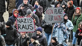 Teilnehmer einer Gegendemonstration gegen eine rechtsradikale Kundgebung in Berlin-Friedrichshain halten Schilder mit Aufschriften wie "Nazis raus" und "Kein Platz für Nazis" hoch. (Quelle: imago-images/Maurizio Gambarini)