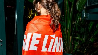 Ein Gast der Wahlparty von Ferat Kocak (Koçak) in Berlin trägt am 23.02.2025 eine Die Linke-Fahne um die Schultern. (Quelle: Picture Alliance/Eventpress Jeremy Knowles)
