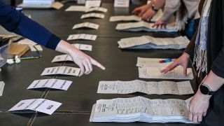 Stimmzettel der Bundestagswahl 2025 liegen am 25.02.2025 bei der öffentlichen Nachzählung von drei Wahlbezirken im Rathaus Schöneberg im Bezirk Tempelhof-Schöneberg auf einem Tisch. (Quelle: Picture Alliance/Jens Kalaene)
