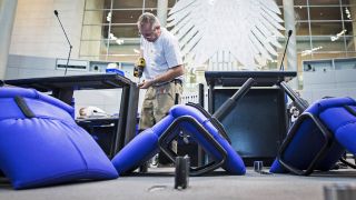 Archivbild:Ein Arbeiter schraubt einen Tisch im Plenarsaal des Deutschen Bundestags in Berlin am 17.10.2027.(Quelle:imago images/Photothek/F.Gaertner)