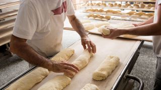 Archivbild: Bäcker bereiten in einer Bäckerei Brot-Teig vor. (Quelle: dpa/shotshop)