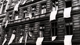 Aus den Fenstern unzerstörter Wohnhäuser in einer Straße in Berlin hängen als Zeichen der Kapitulation weiße Tücher, aufgenommen Ende April 1945. (Quelle: dpa-Zentralbild/Jewgeni Chaldej)