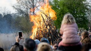 Symbolbild: Menschen stehen am Karsamstag um das Osterfeuer im Britzer Garten. (Quelle: dpa/Fabian Sommer)
