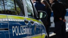 Symbolbild: Polizeiwagen und Polizisten stehen im Umkreis des Fundorts der Leiche. (Quelle: dpa/Hannes P Albert)