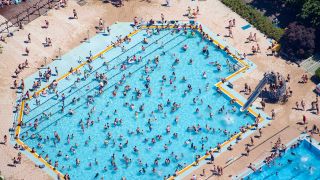 Kinder und Erwachsene baden und sonnen sich am 30.06.2019 im Sommerbad Wuhlheide in Berlin. (Quelle: dpa-Bildfunk/Gregor Fischer)