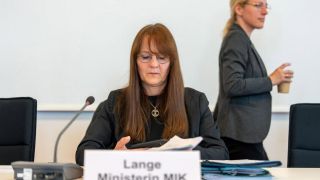 Katrin Lange (SPD), Brandenburgs Ministerin des Inneren und für Kommunales, bereitet sich in einer Pause der Sitzung des Landtags-Ausschusses für Inneres und Kommunales auf die Fortsetzung vor. Hinter ihr geht Lena Kotre (AfD) vorbei. (Quelle: dpa/Stache)