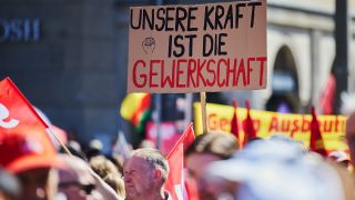 01.05.2025, Berlin: Ein Plakat mit der Aufschrift "Unsere Kraft ist die Gewerkschaft" ist auf einer Demonstration zum 1. Mai auf der Karl-Marx-Alle zu sehen.(Quelle:dpa/J.Carstensen)