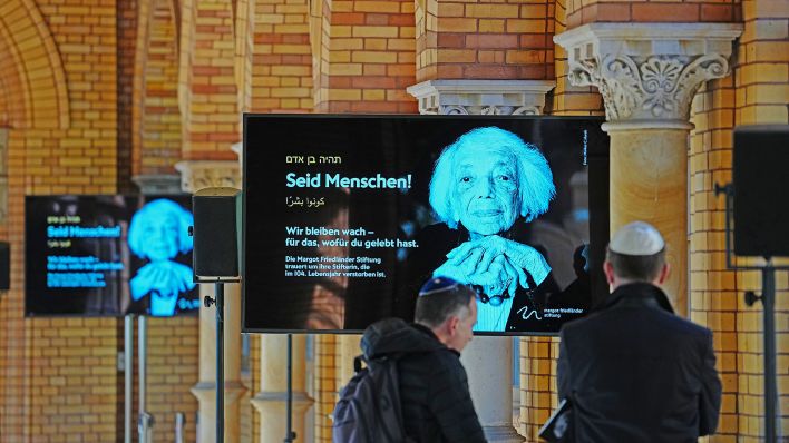 15.05.2025, Berlin: "Seid Menschen" steht neben einem Bild der Holocaust-Überlebenden Margot Friedländer auf einer Leinwand im Friedhof Weißensee der Jüdischen Gemeinde zu Berlin.(Quelle:dpa/K.Nietfeld)