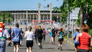 Läuferinnen und Läufer joggen im Rahmen des S25-Laufs auf das Berliner Olympiastadion zu. (Foto: IMAGO / Funke Foto Services)