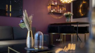 Ein Couch-Tisch mit Deko steht vor einem Sofa und einem Esstisch in einer Berliner Wohnung. (Quelle: imago-images/photothek)