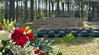 Särge mit deutschen Kriegstoten stehen für die Beisetzung auf dem Rasen (Foto: rbb/Krippahl)